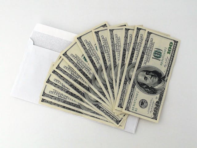 cash fanned out over white envelope